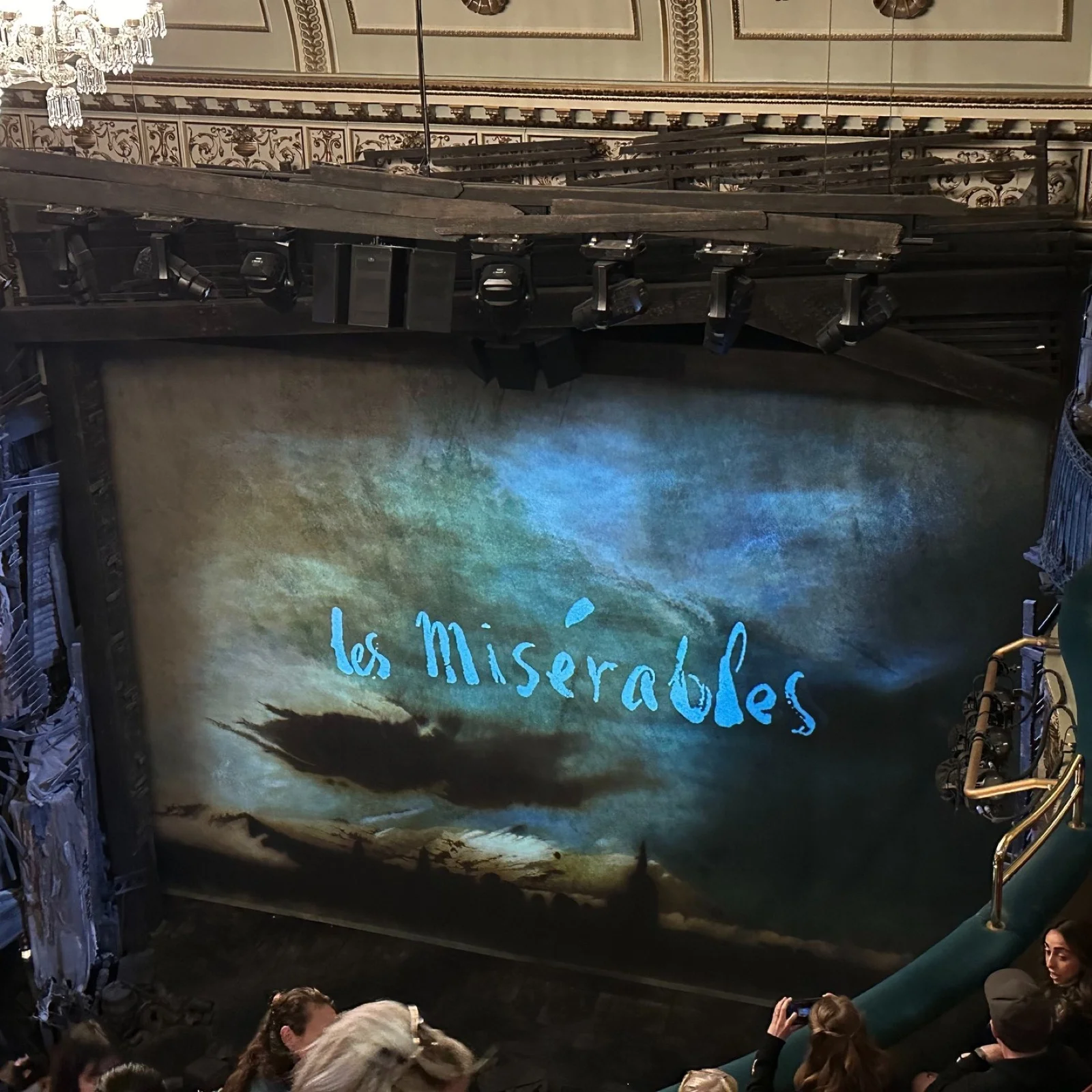 《悲慘世界》開演前,舞台布幕上投影著藍色的 Les Misérables 字樣